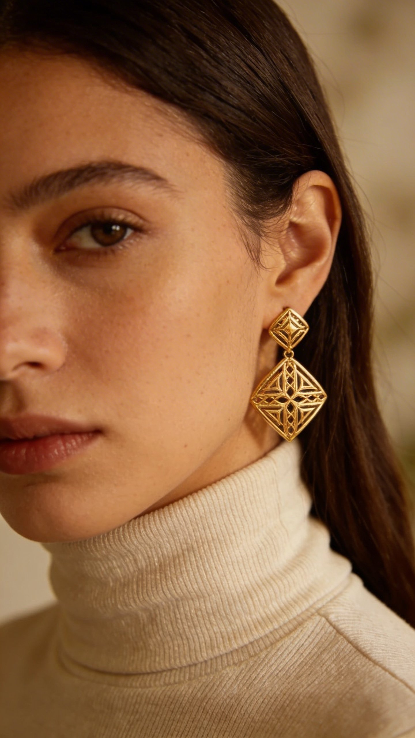 Woman wearing turtleneck with gold statement earrings closeup