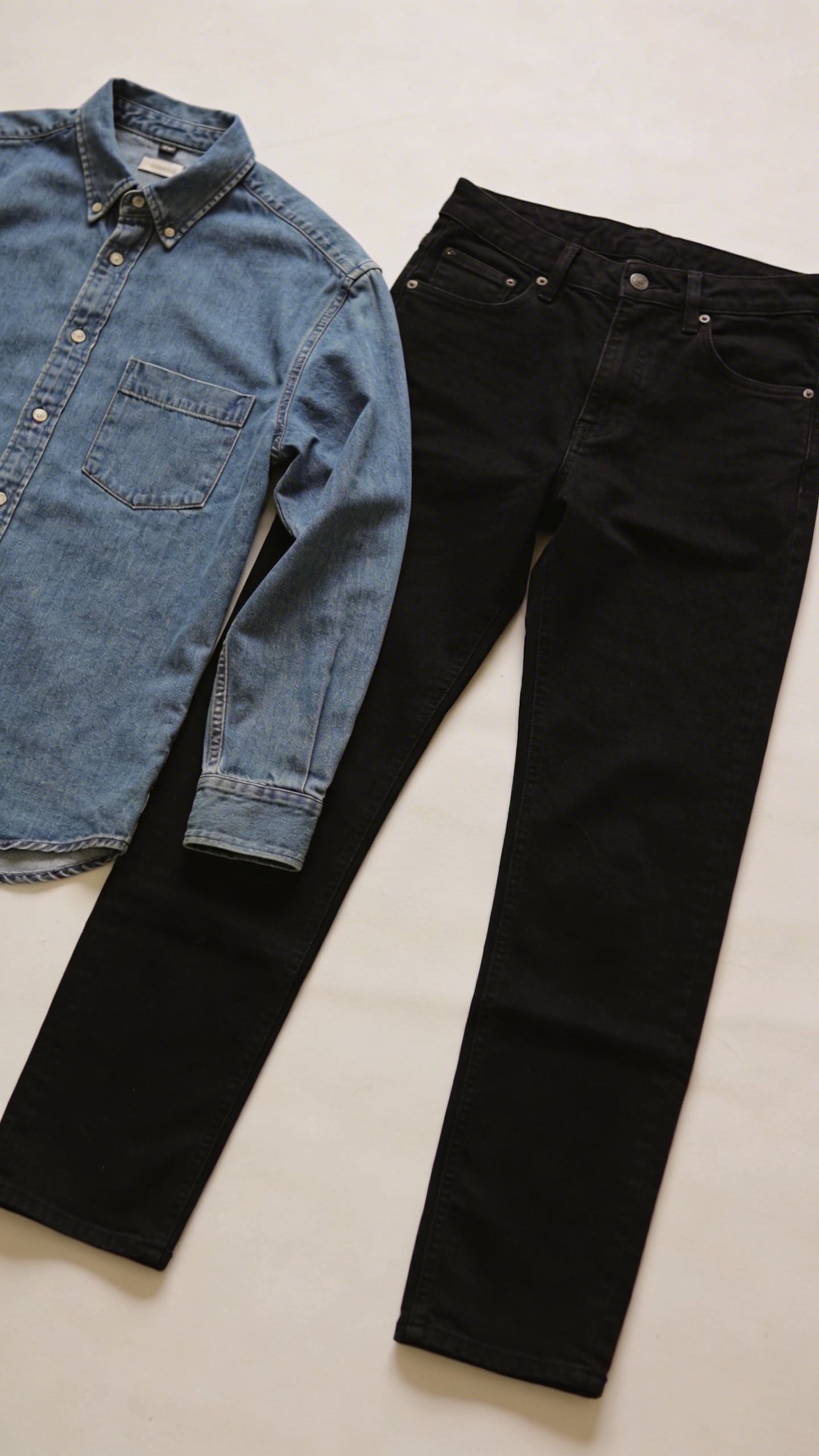 Denim shirt layered with black jeans casual outfit flat-lay