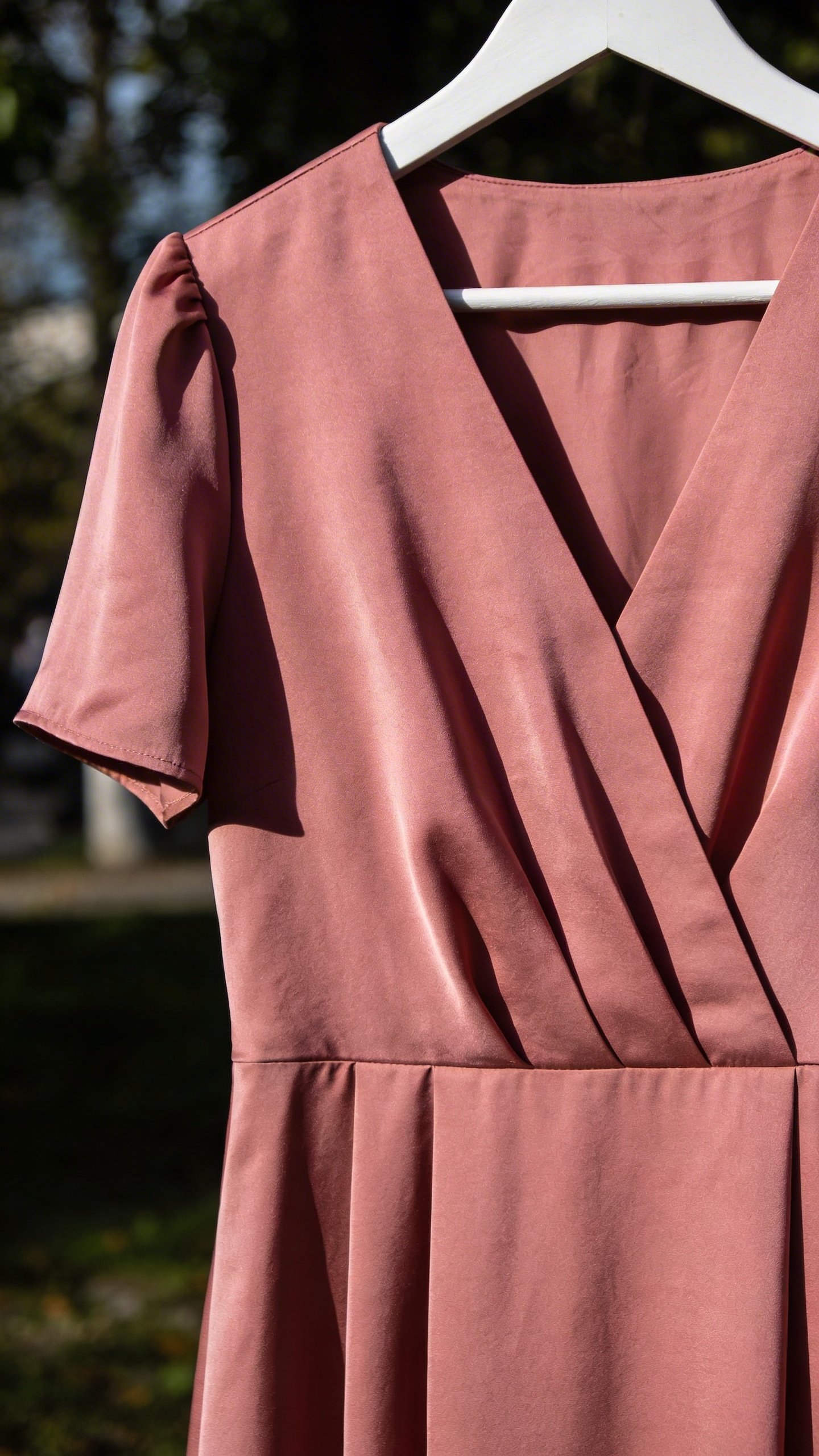 Dusty pink midi dress on white hanger closeup
