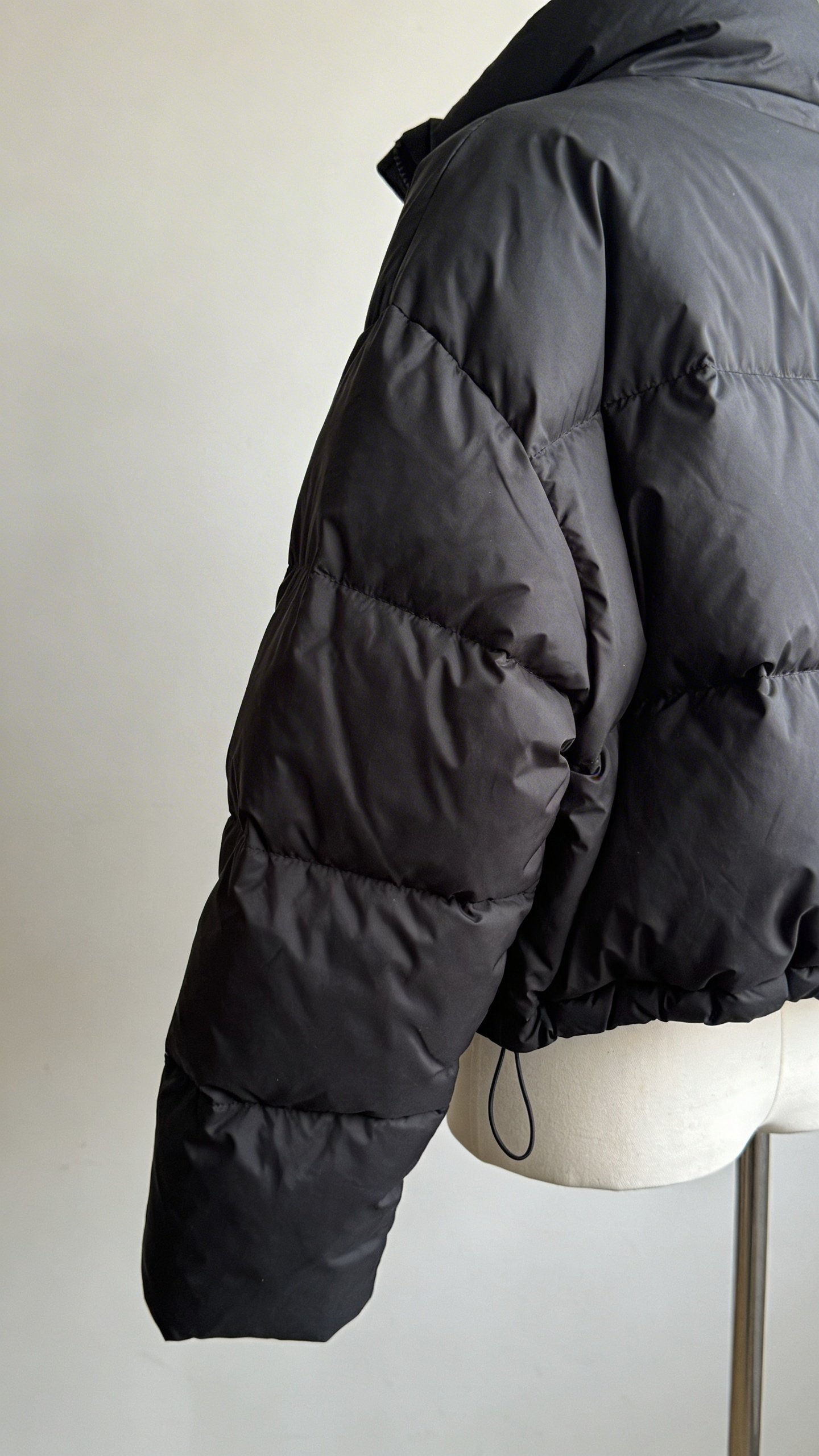 Closeup of black oversized puffer jacket on mannequin