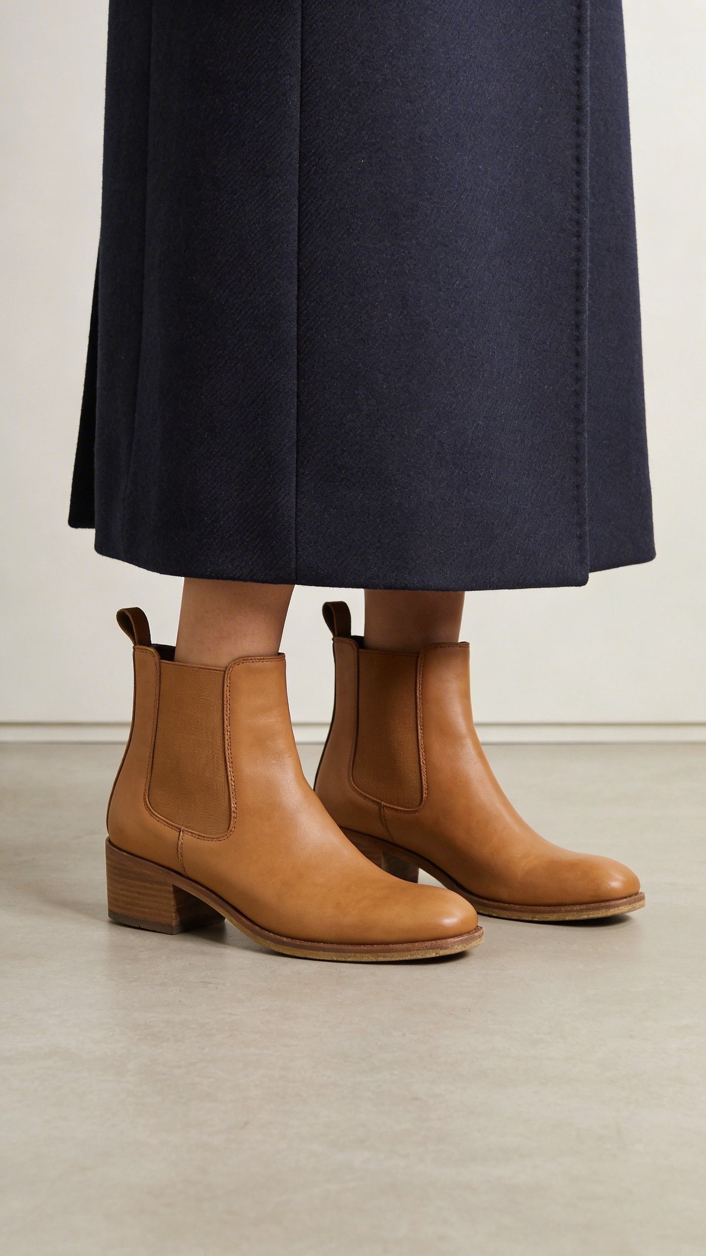 Navy wool coat paired with tan Chelsea boots