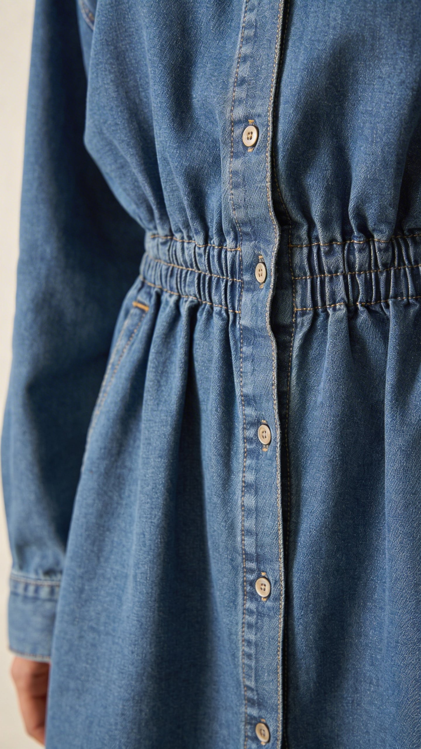 Closeup of oversized denim shirt with front hem tucked