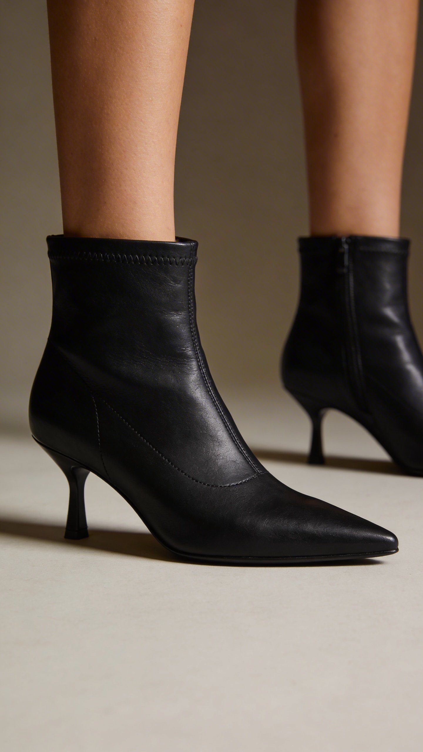Closeup of black pointed-toe heeled ankle boots