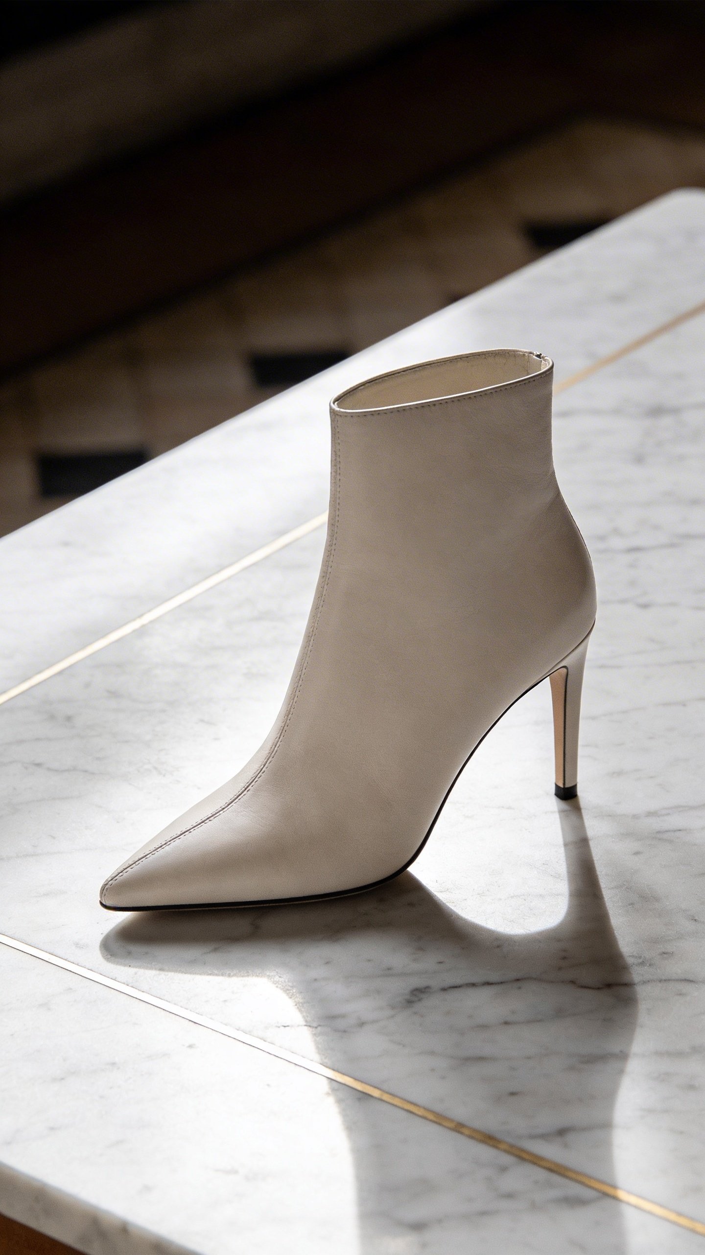 Close-up of stiletto heel ankle boot on marble