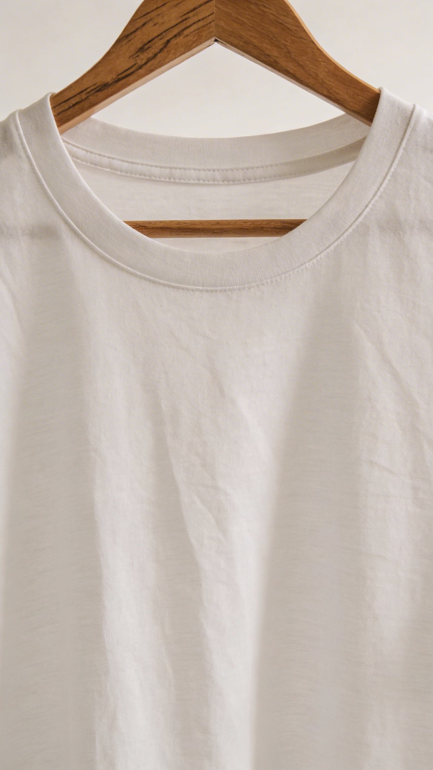 Closeup of white cotton t-shirt on wooden hanger