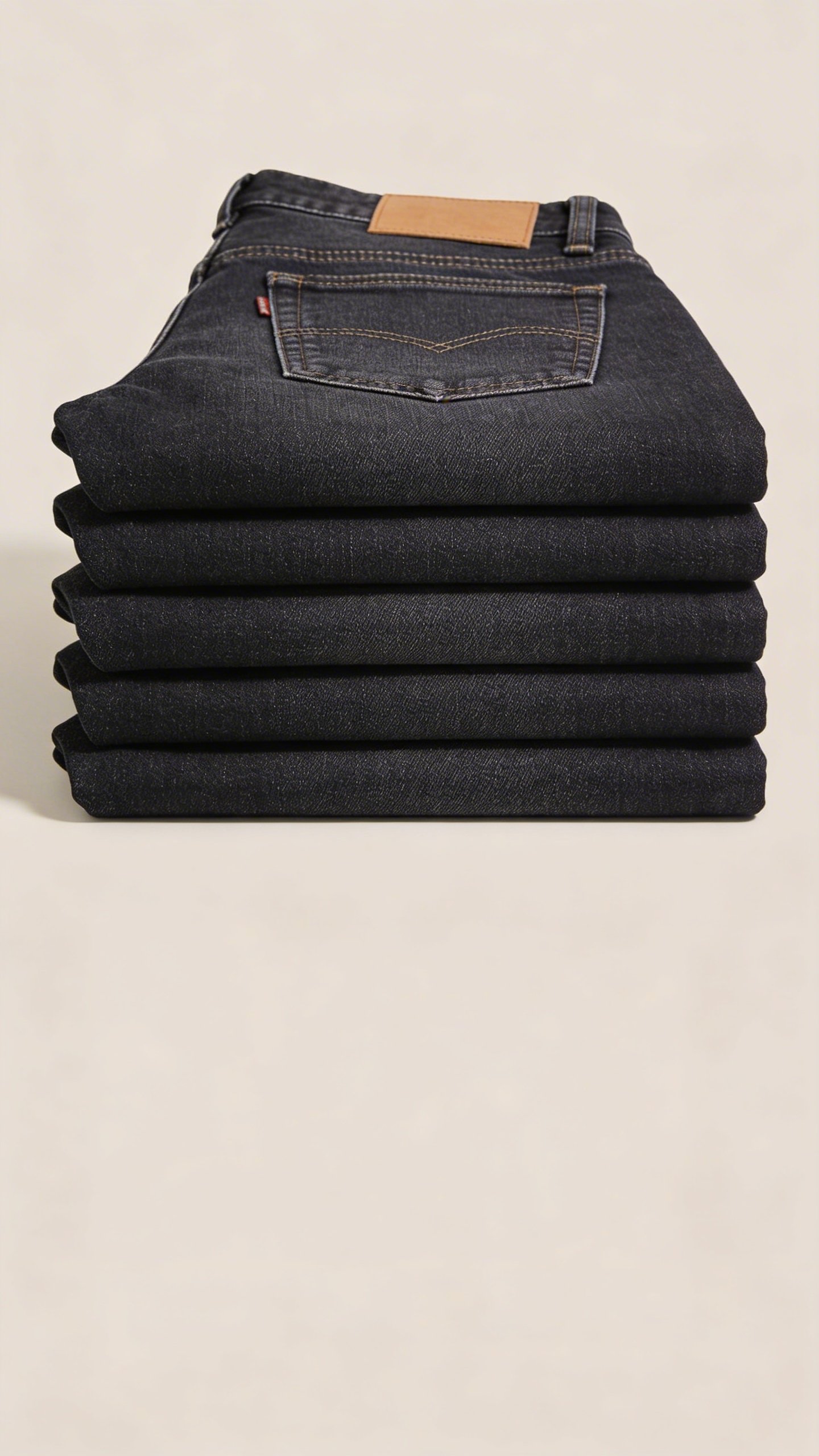 Well-fitted dark wash denim jeans folded neatly