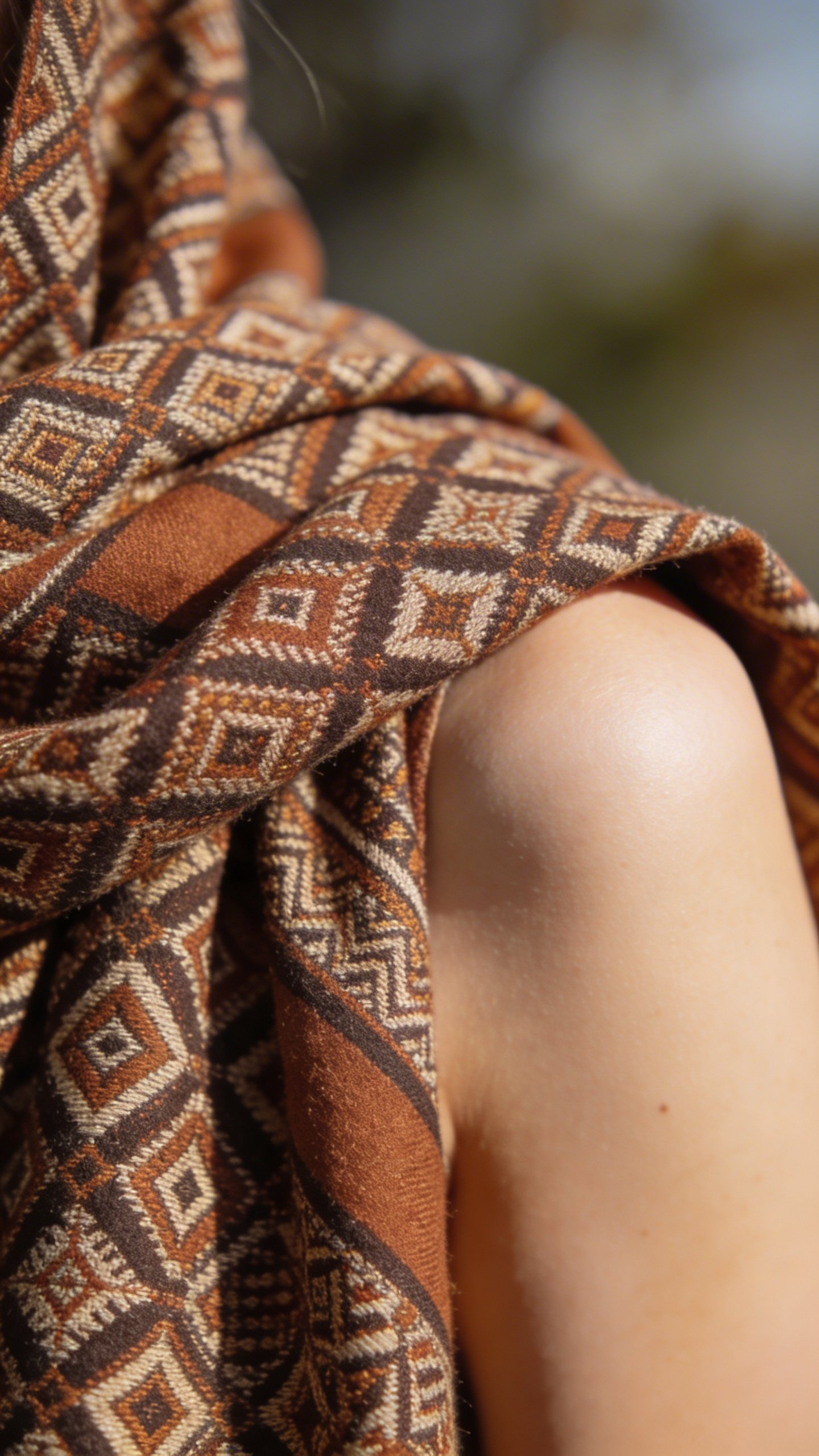 Patterned scarf draped asymmetrically over one shoulder closeup