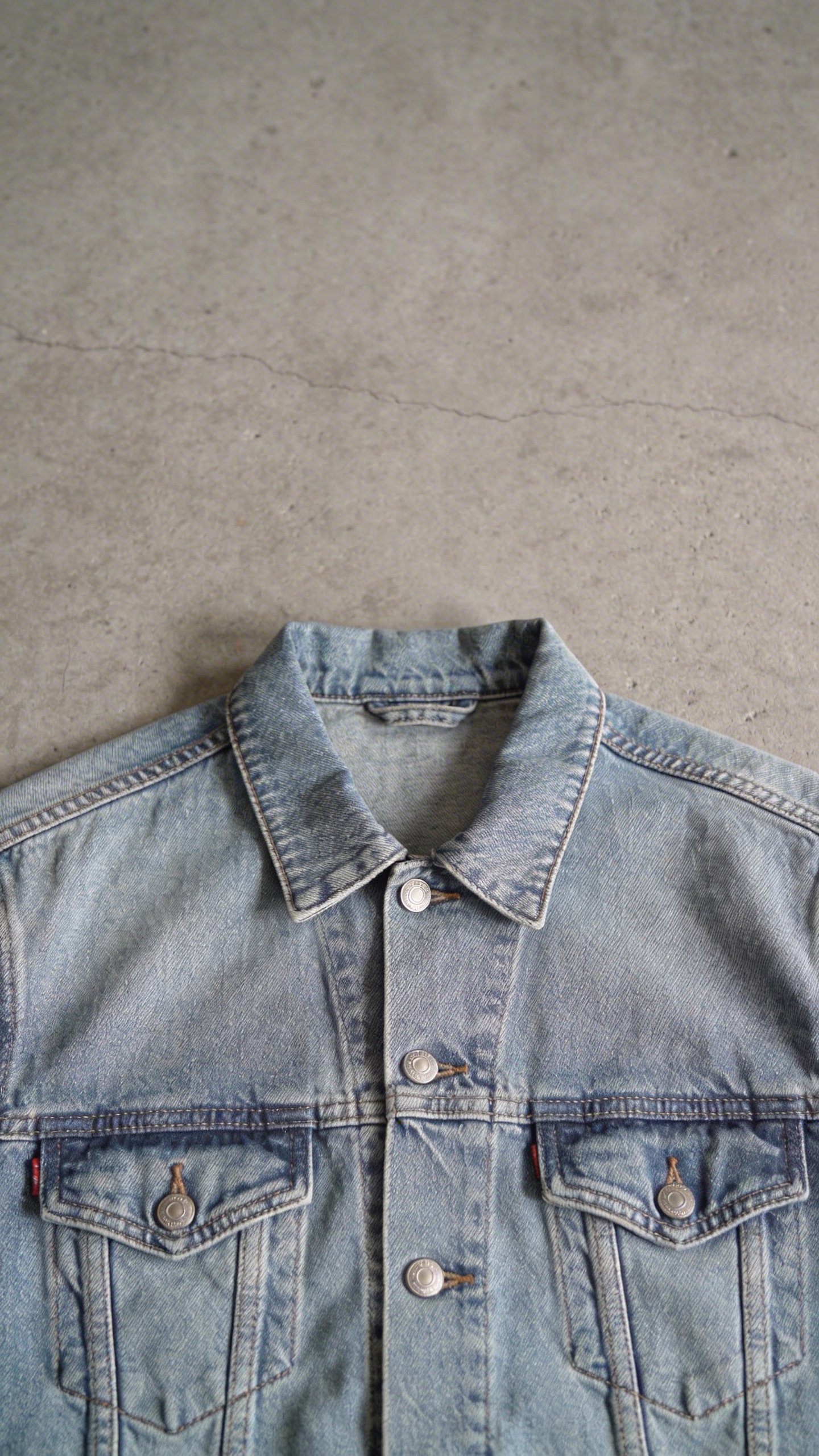 Closeup fashion flat lay single denim jacket concrete
