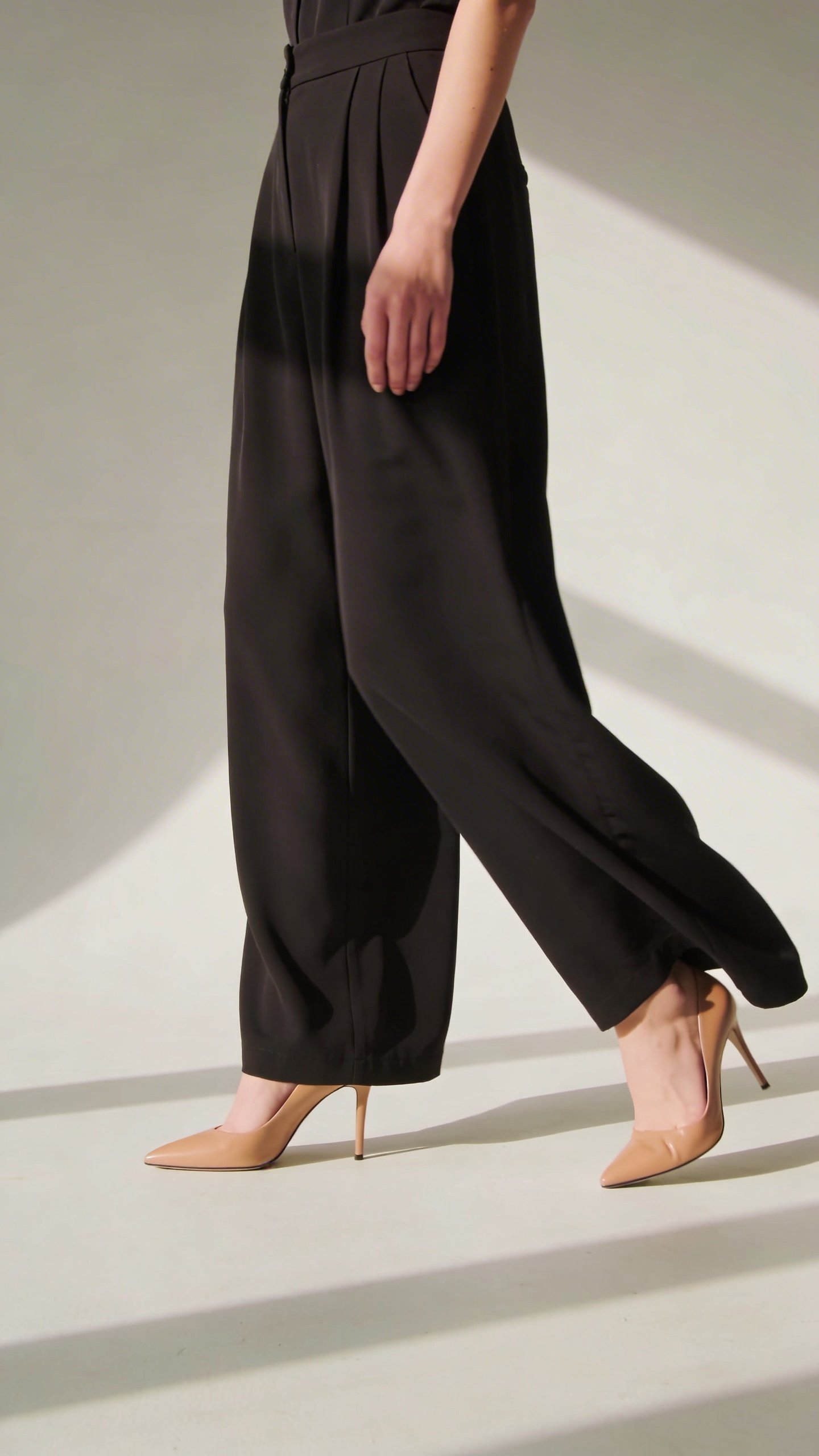 Black wide-leg jumpsuit with pointed-toe nude heels