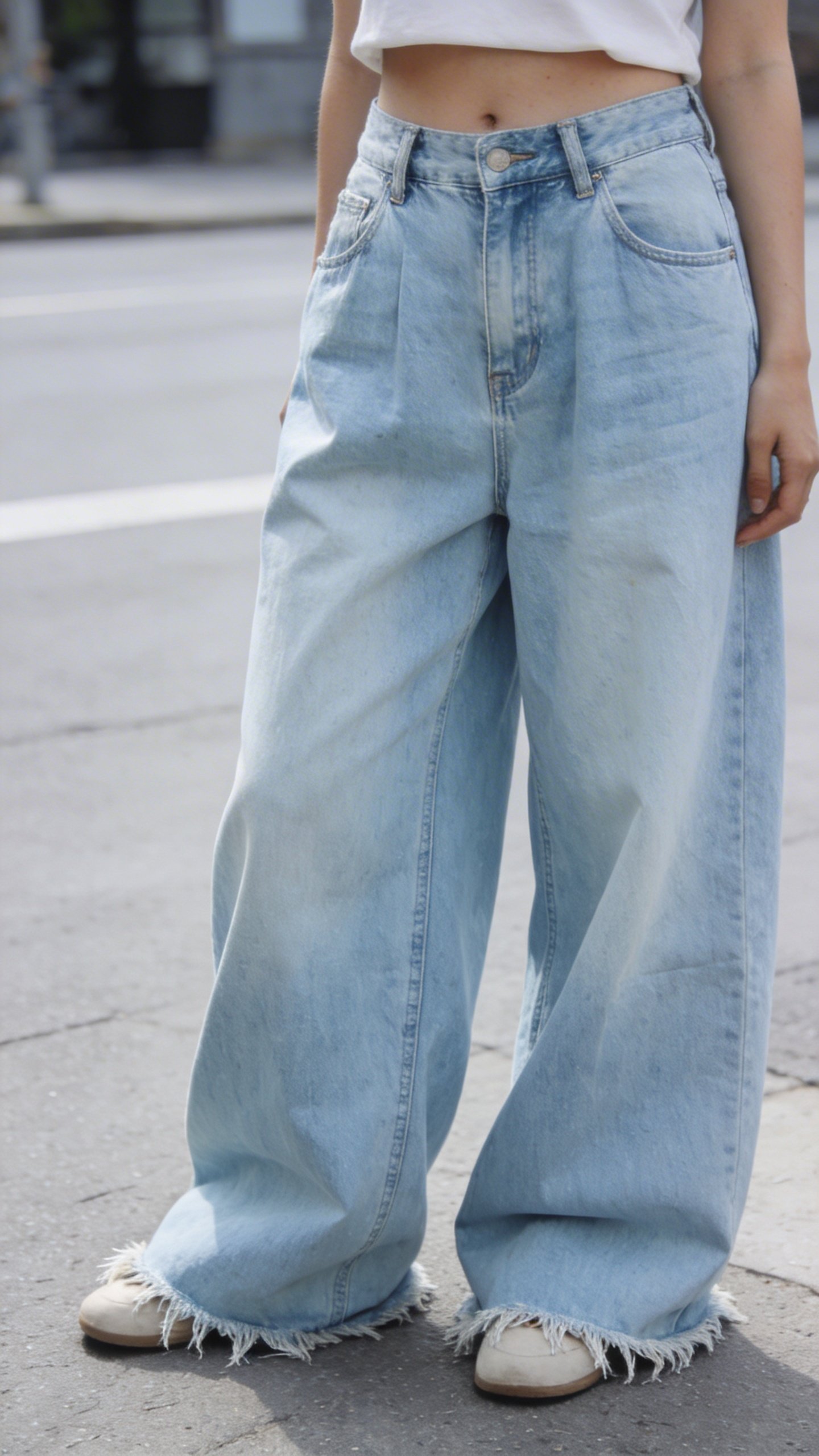 Woman wearing light wash baggy denim jeans, waist-down shot