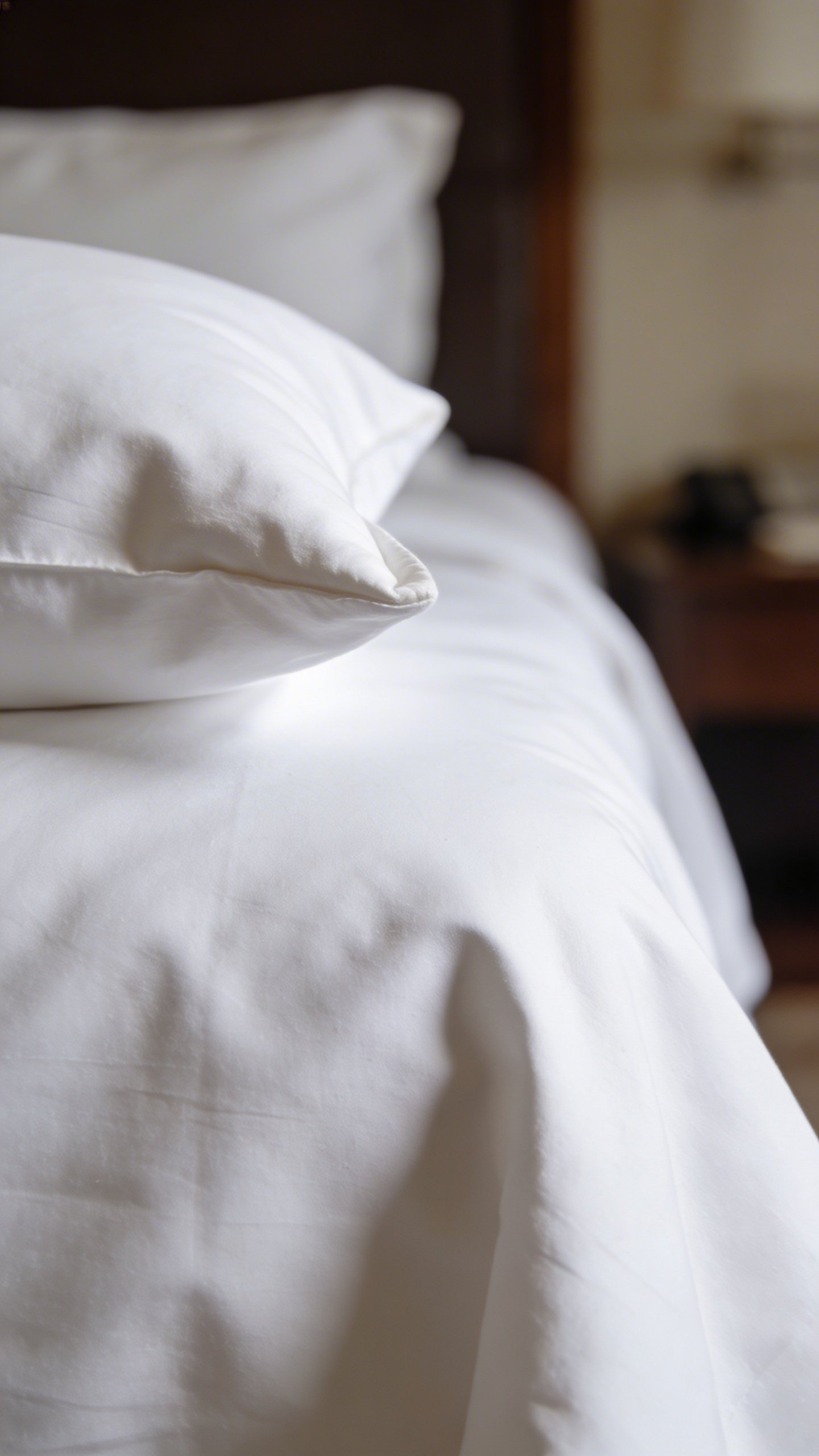 Closeup of white hotel-style bedding with folded corner