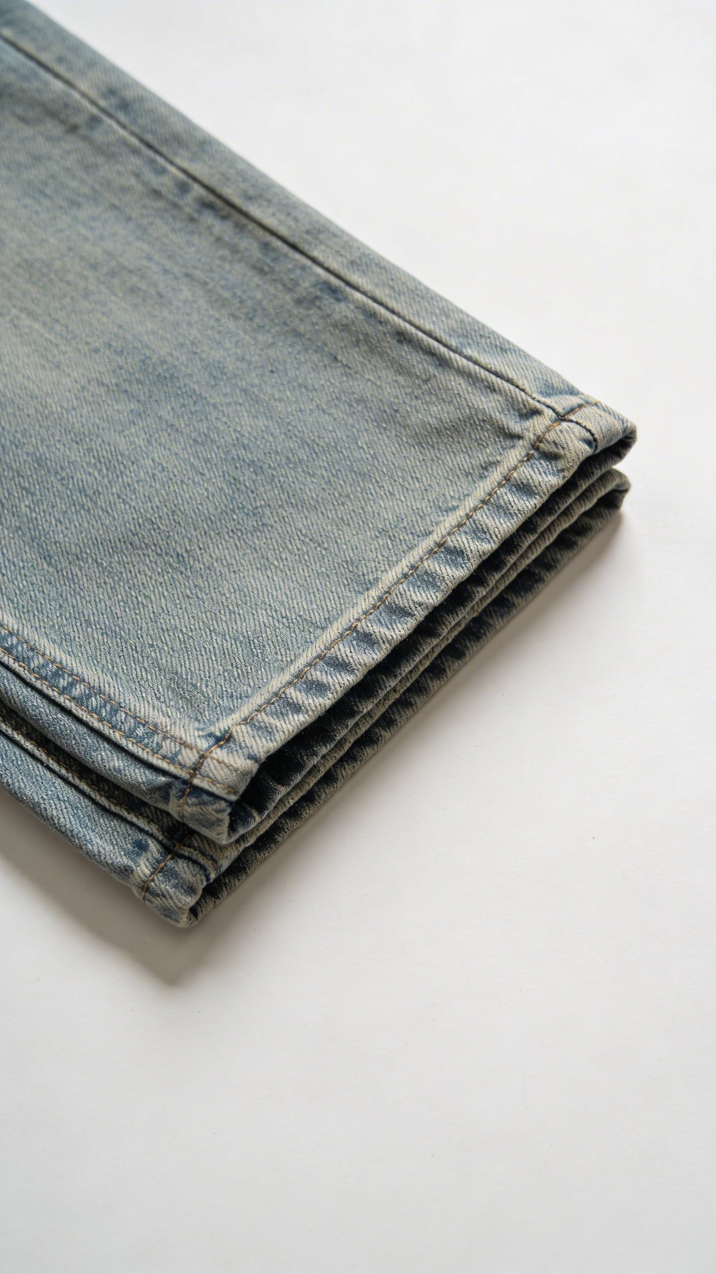 Overhead view of folded jeans on white background