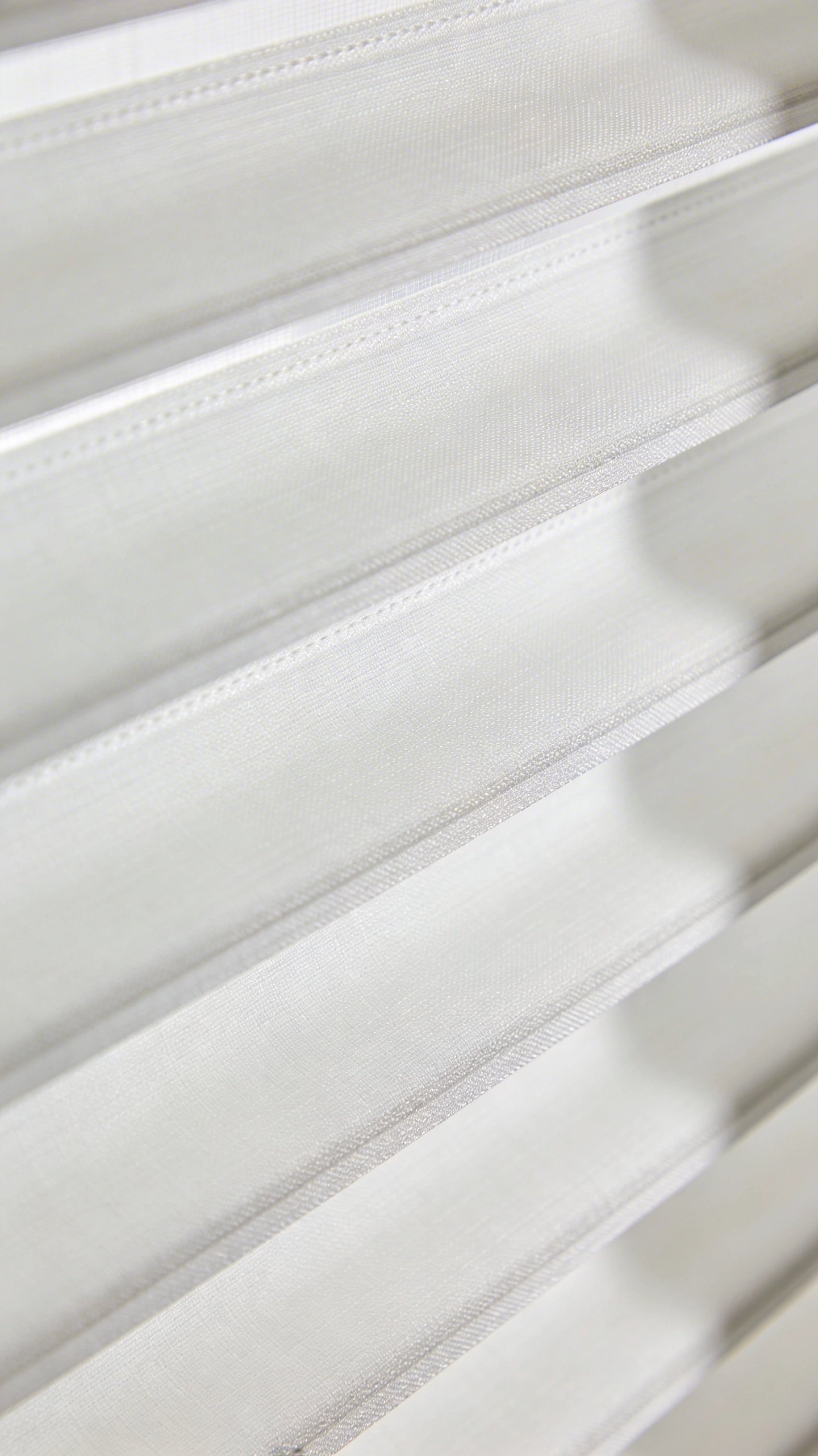 Closeup of light-filtering roller blind in white fabric