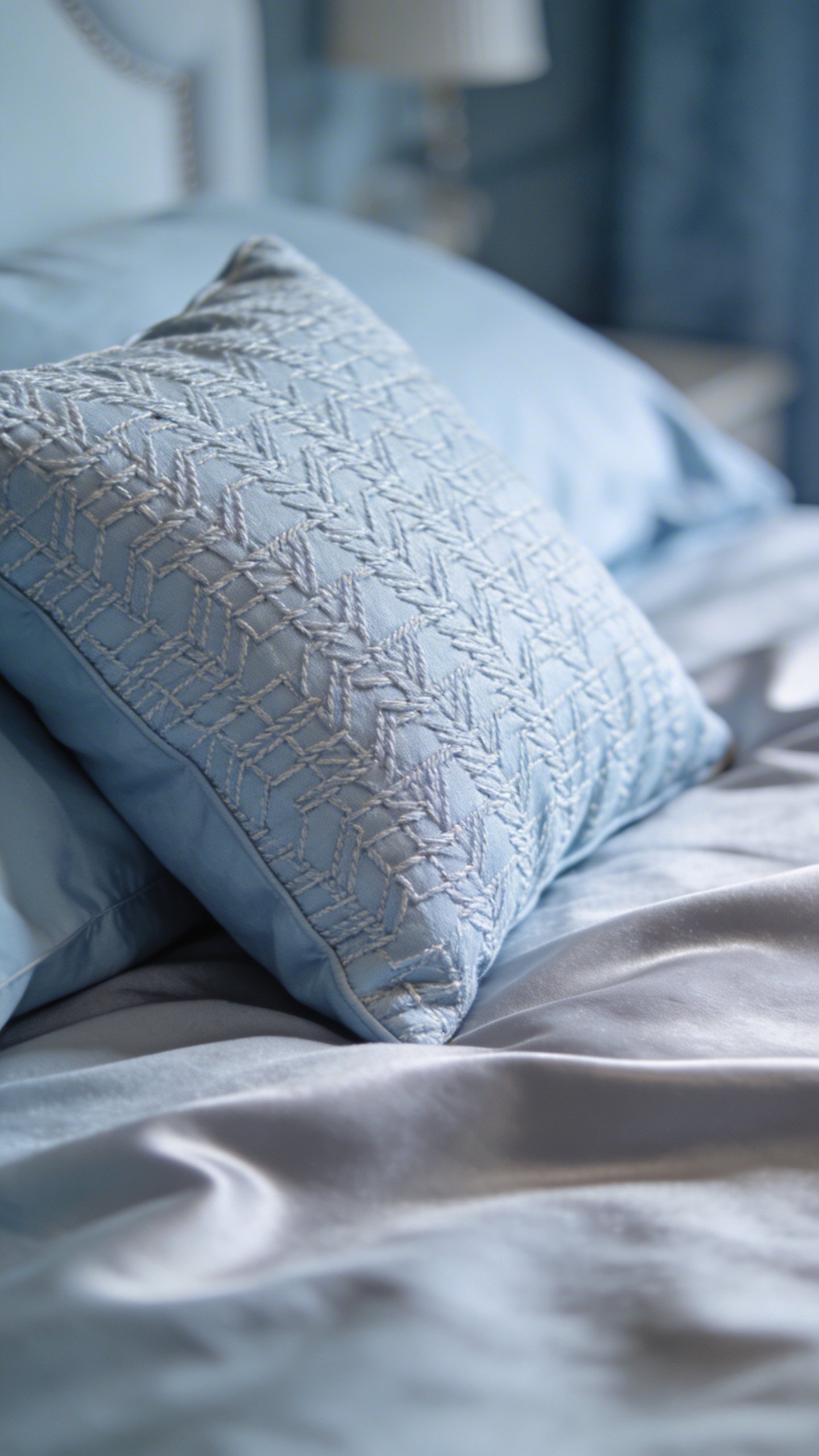 Closeup of pale blue decorative throw pillow on bed