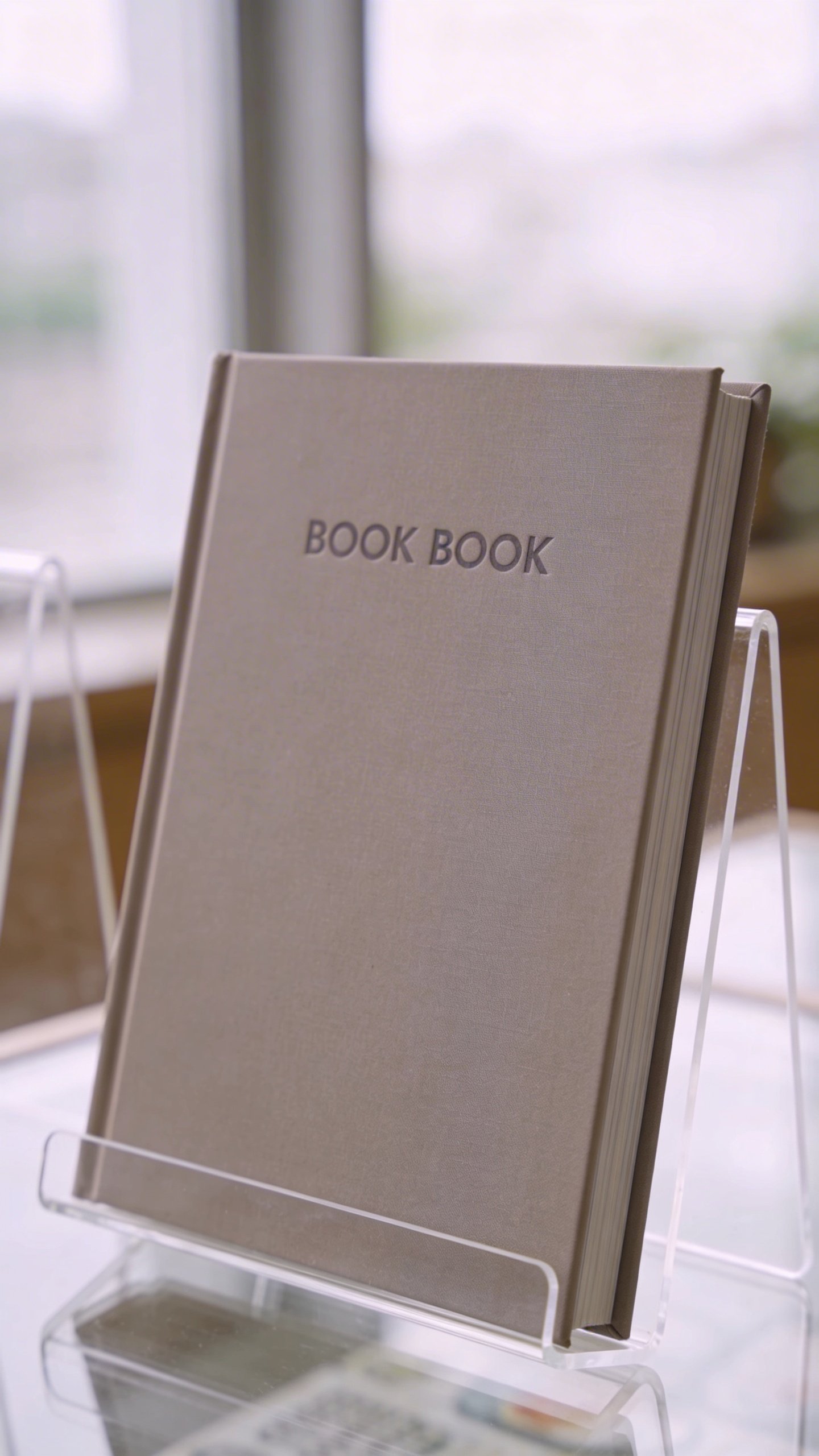Modern cookbook standing upright on acrylic display stand
