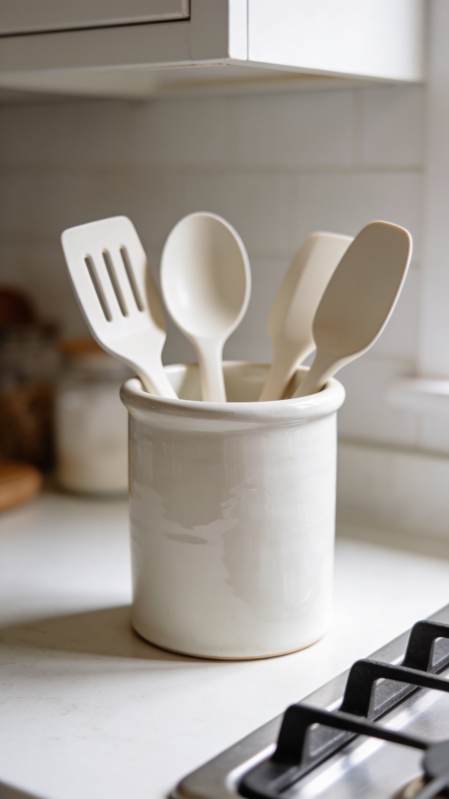 Closeup of white ceramic utensil crock on counter