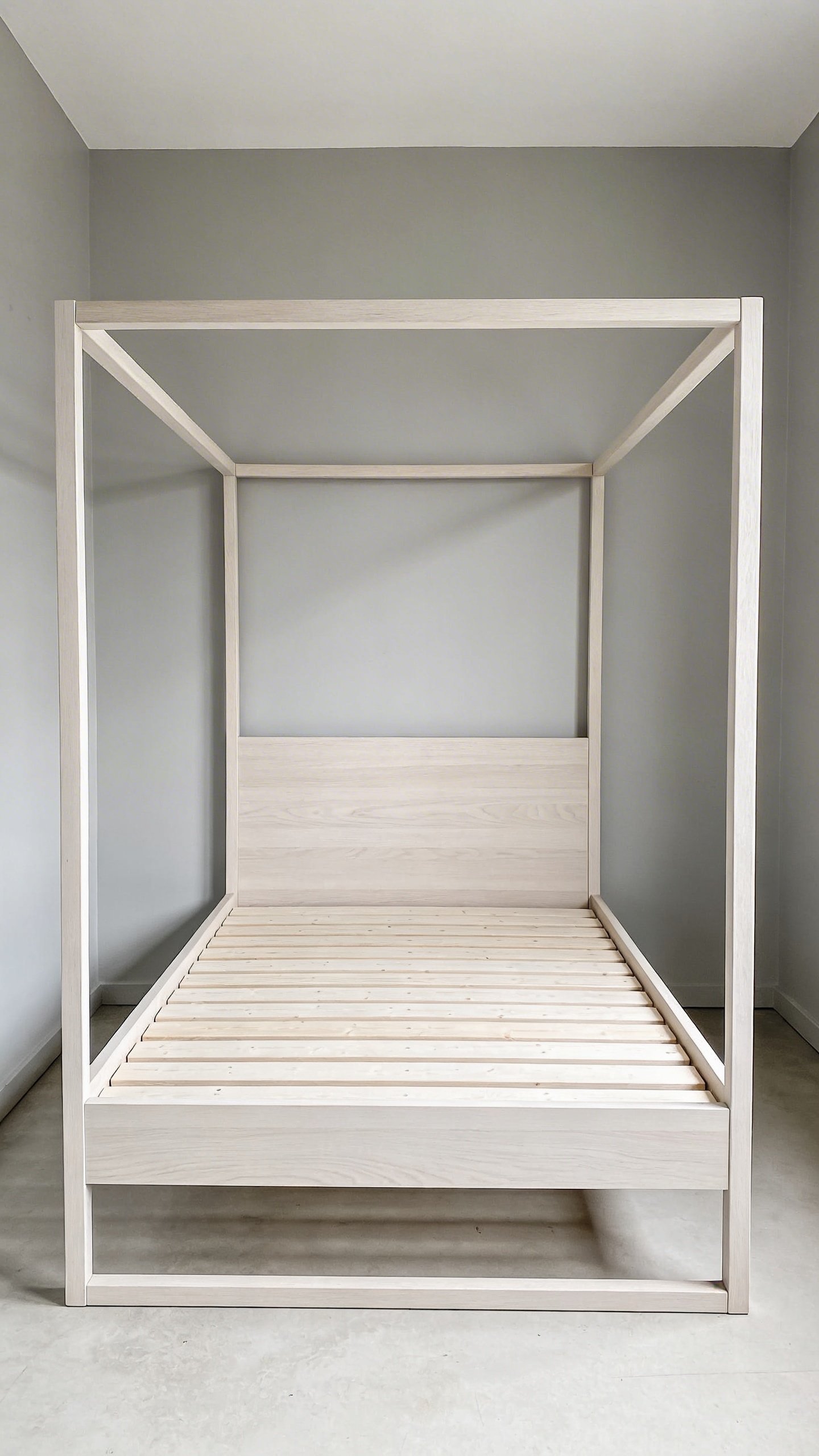 Compact full-size bed frame against light gray wall