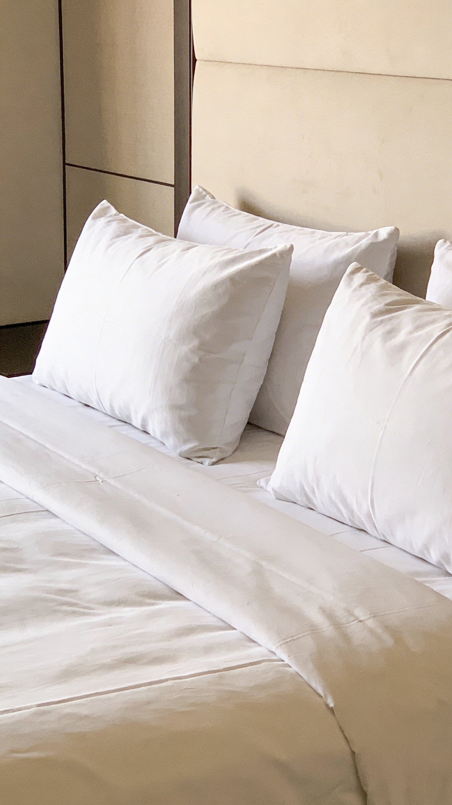 Neatly made bed with white duvet and pillows