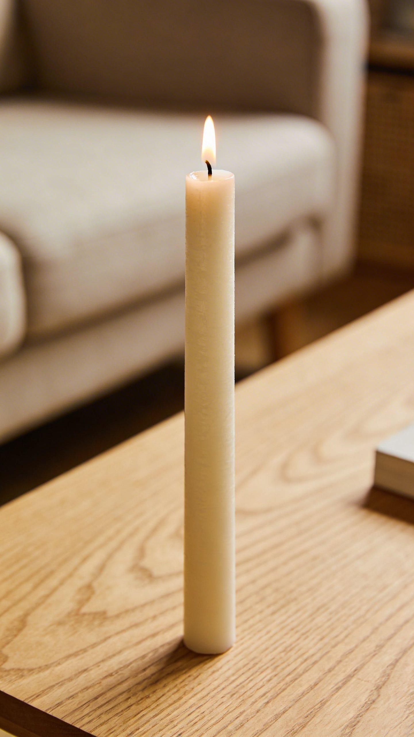 Medium ivory pillar candle on coffee table