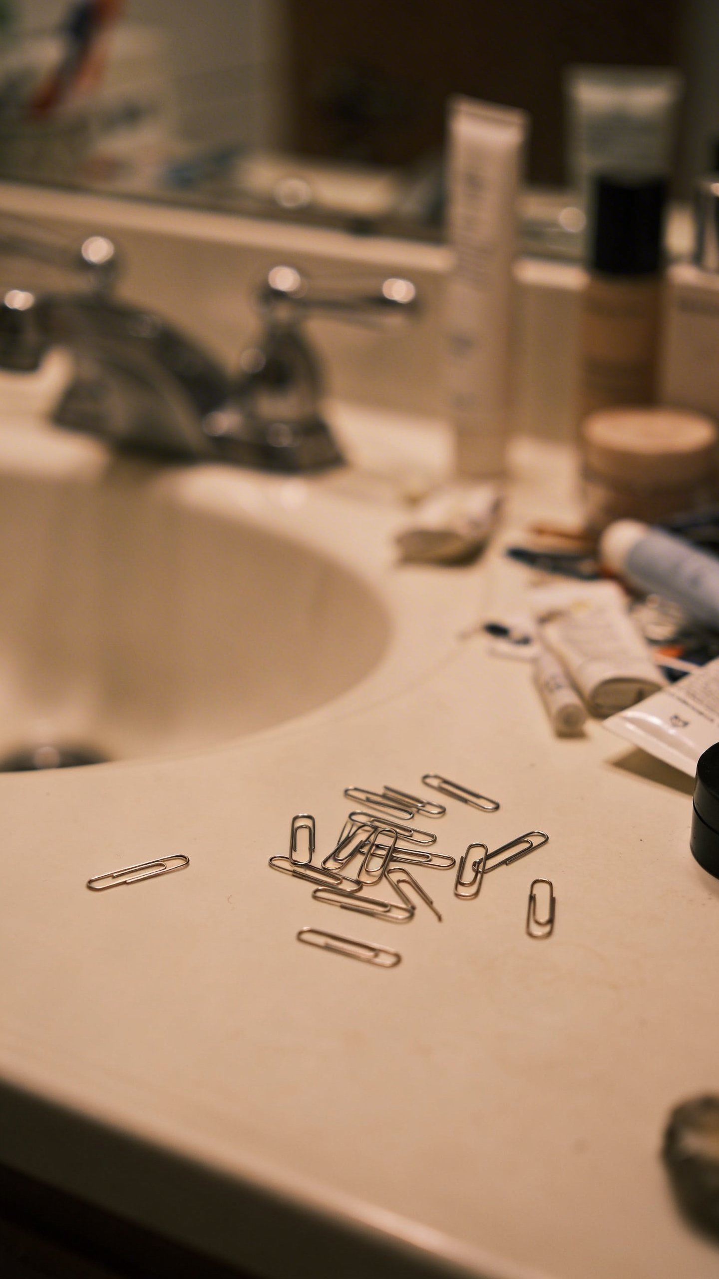 Cluttered bathroom counter with scattered bobby pins